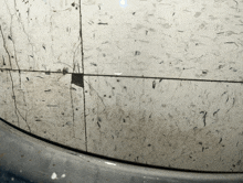 a close up of a dirty tile floor with a black square in the middle