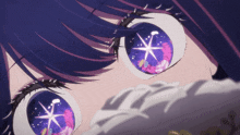 a close up of a girl 's eyes with a purple star in them