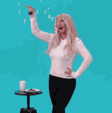 a woman standing in front of a table with a plate of cookies and a glass of milk on it