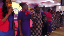 a group of women singing in front of a sign that says " may your heart be filled with compassion "