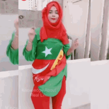 a woman wearing a red hijab and a green shirt with a star on it .