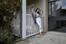 a woman standing on a porch with a striped shirt on