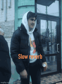 a man wearing a hoodie and a shirt that says slow revers