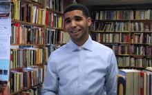 a man in a light blue shirt is smiling in front of a bookshelf with a book titled " a brief history " on it