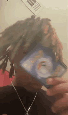 a man with dreadlocks is holding a card in his hand .