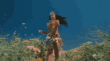 a naked woman in a field of flowers