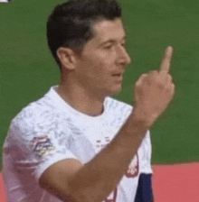 a soccer player is giving the middle finger while standing on a field .