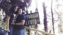 a man and a woman standing in front of a sign that says parada 1 foto