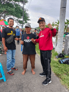 a man wearing a red sweater that says enama on it