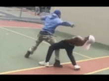 a man in a blue jacket is standing next to a woman on a basketball court .