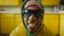 a close up of a man wearing sunglasses and a rainbow beanie