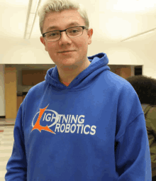 a boy wearing a blue hoodie that says lightning robotics