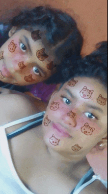 two girls with cats on their faces are posing for a photo