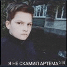 a young boy is standing in front of a building in a dark room .