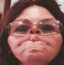 a close up of a woman wearing glasses making a face