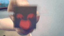 a person is holding a piece of paper that has a red heart on it