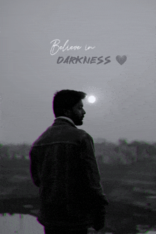 a black and white photo of a man with the words " believe in darkness " below him