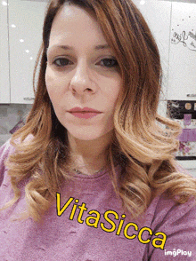 a woman wearing a purple sweater with vitasicca written on the bottom