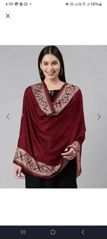 a woman wearing a maroon shawl with gold embroidery on it