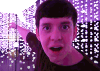 a man with a surprised look on his face in front of purple lights