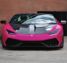 a pink lamborghini is parked in front of a building