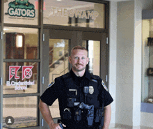 a police officer is standing in front of a glass door that says the swamp