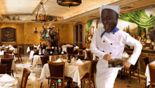 a chef is dancing in a restaurant while holding a picture of food in his hand