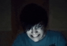 a close up of a person 's face in a dark room with a smile on their face .