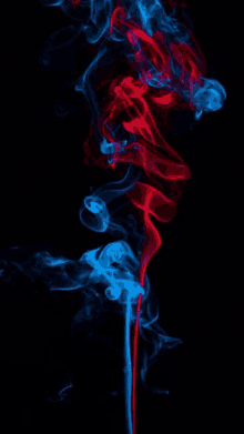 a red and blue smoke swirls on a black background