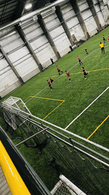 a group of kids are playing indoor soccer on a field