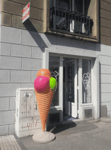 a giant ice cream cone in front of a store that says ' ice cream ' on it