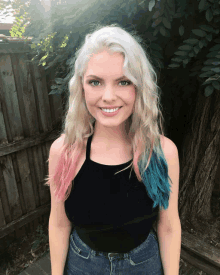 a woman with pink and blue hair wearing a black top