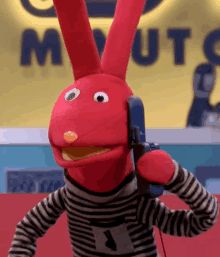 a red bunny puppet is talking on a blue phone