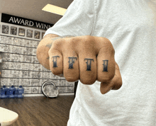 a man with a tattoo on his fingers that says tfti