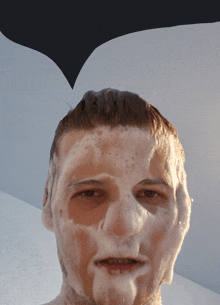 a man 's face is covered in soap and foam