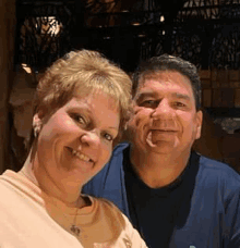 a man and a woman are posing for a picture together in a restaurant .