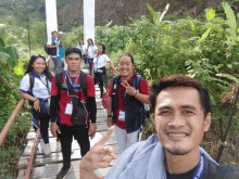 a group of people standing on a bridge with one man wearing a lanyard that says ' aguila ' on it