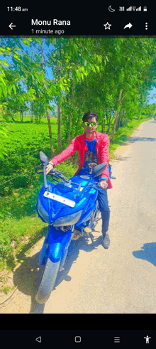 a phone screen shows a picture of a man riding a blue motorcycle with the name monu rana at the bottom