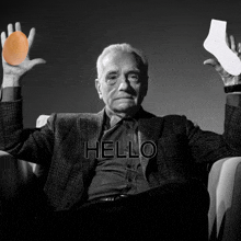 a man in a suit holds an egg and a socks in his hands with the word hello written above him