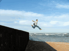 a man is jumping in the air over a beach