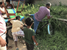 a group of children are playing with a bicycle that says racing bike on it