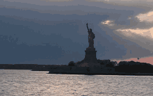 the statue of liberty is standing in the middle of the ocean