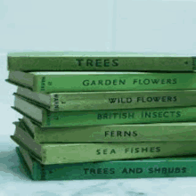 a stack of green books including trees garden flowers wild flowers british insects