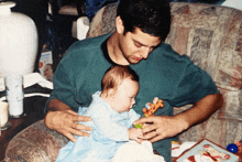 a man holding a baby wearing a shirt that says ' i love you ' on it