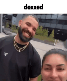 a man with a beard is smiling next to a woman with the word doxxed on the bottom