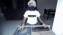 a person wearing a white fortnite balenciaga shirt sits at a desk