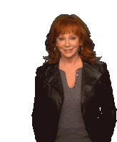 a woman with red hair wearing a black jacket