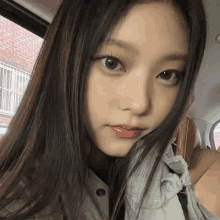 a close up of a girl 's face with a brick wall in the background