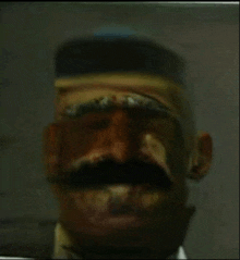 a close up of a man 's face with a hat and mustache