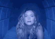 a woman with long blonde hair is in a dark room